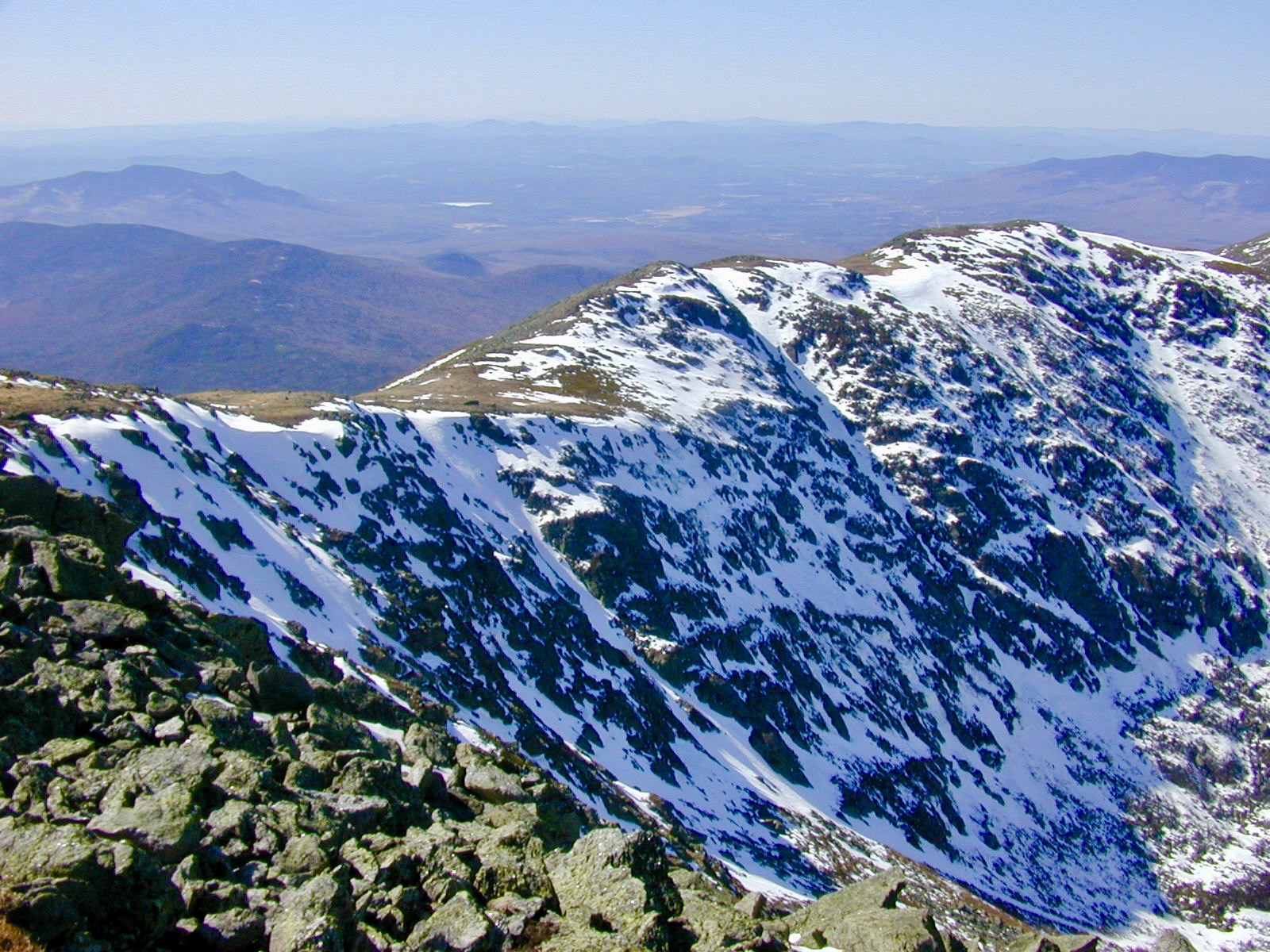 A broad view across the snow-covered ravines and neighboring peaks.